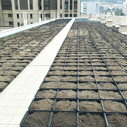 A set of empty modular green roof trays, ready to be filled with soil and plants for a new green roofing project.